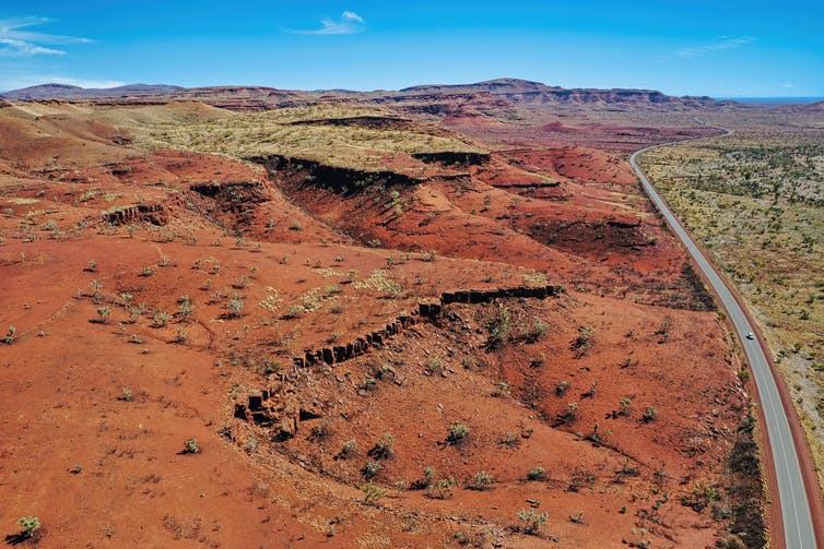 Afbeelding van de Pilbara-regio in West-Australië, bekend om de rode aarde en zijn enorme minerale afzettingen in ijzererts - zuurstof en ijzeratomen die aan elkaar zijn gebonden tot moleculen.