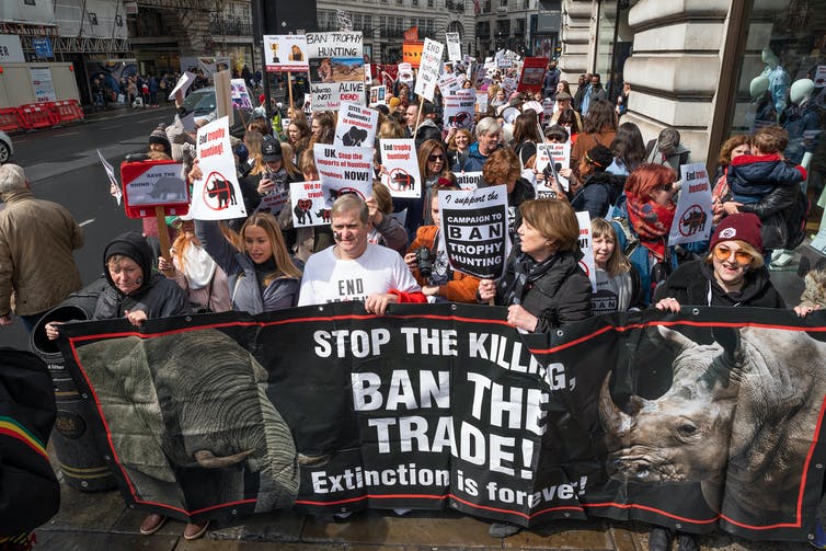 Mensen marcheren door Londen met spandoeken tegen trofeejacht en uitsterven