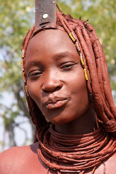 Beeld van een Himba vrouw uit het noorden, cosmetisch versierd met rode oker.