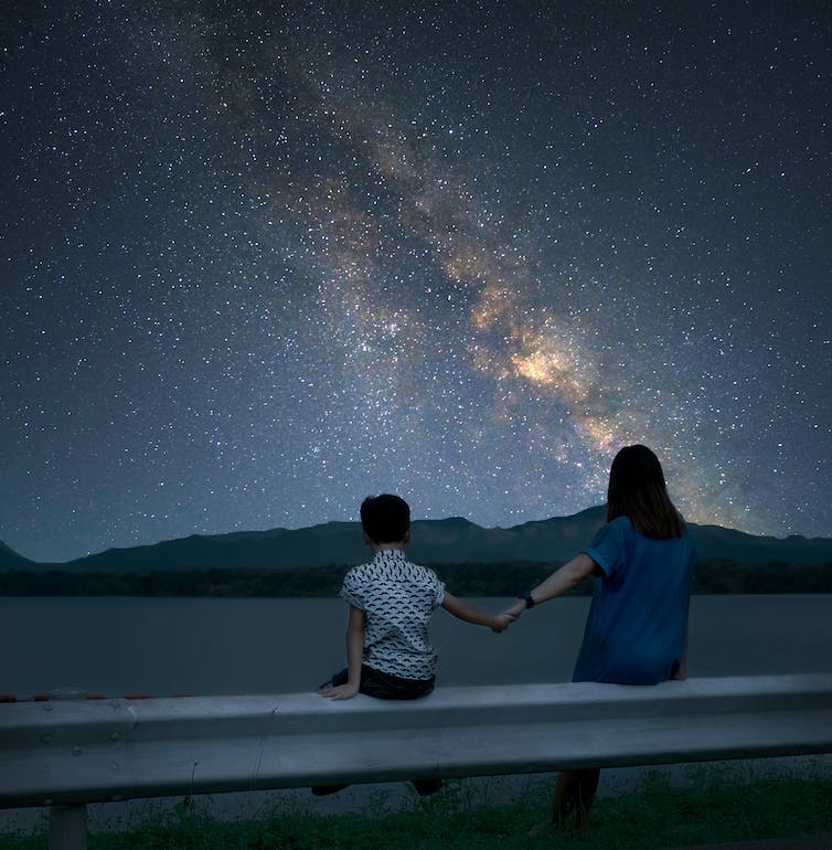 Moeder en kind kijken omhoog naar de Melkweg