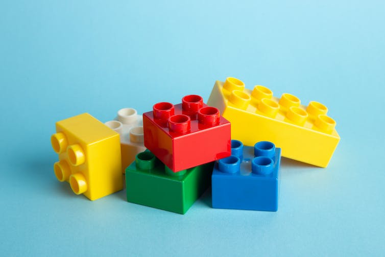 Een hoop gele, rode, groene en blauwe Lego op een hoop.