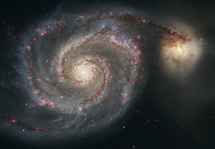 Het Draaikolkstelsel, bekend als M51, en een begeleidend sterrenstelsel.
