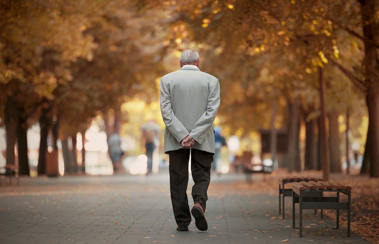 Oudere man wandelt in het herfstpark