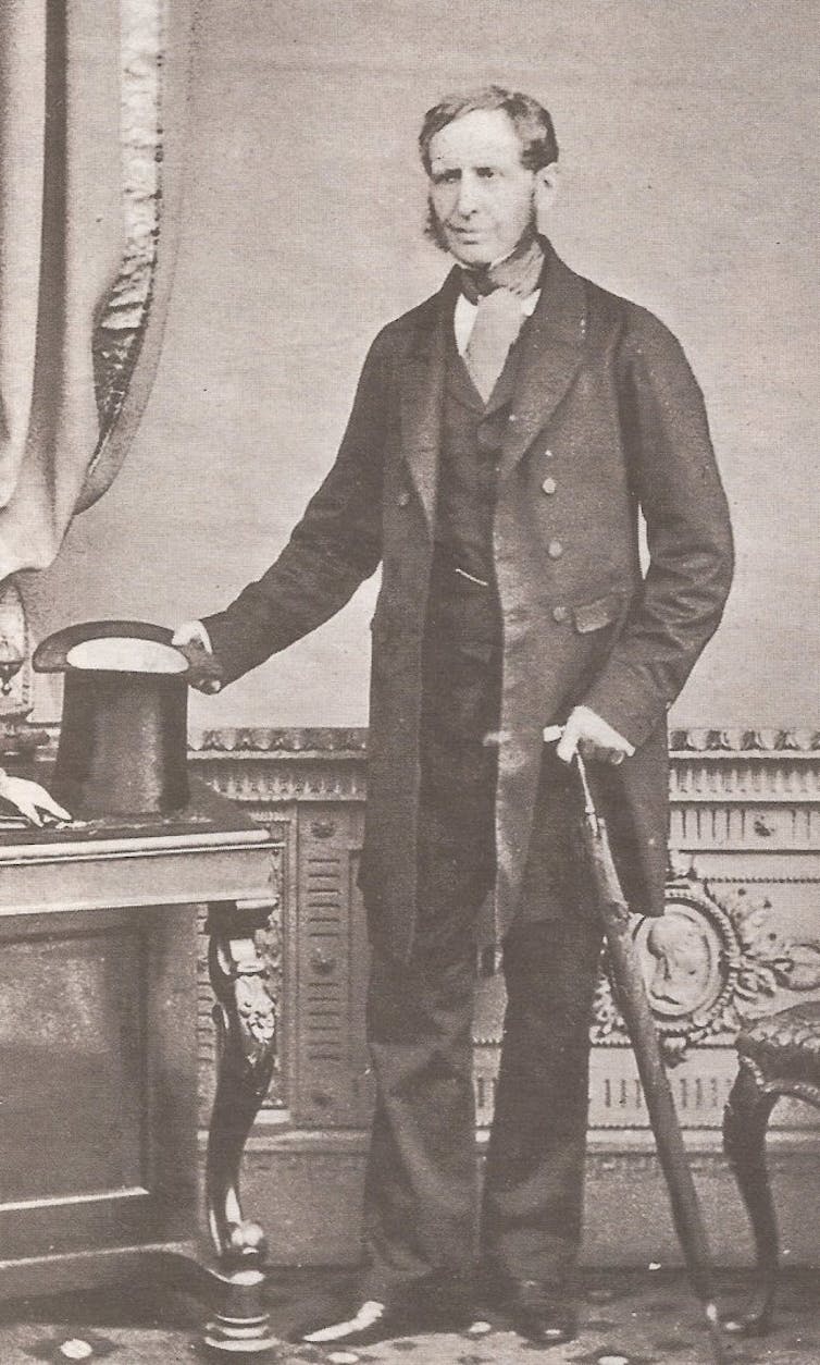 Een oude zwart-wit foto van een man in een jacquet