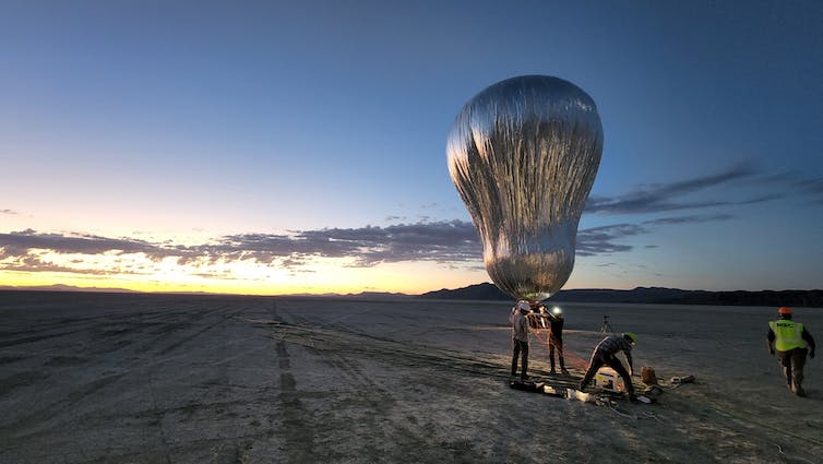 Grote zilveren ballon wordt opgelaten in de woestijn.
